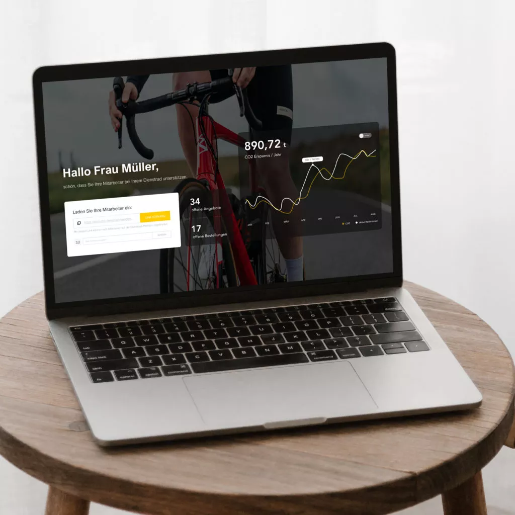 Laptop on a wooden table displaying a dashboard, including data on CO2 savings, open offers, and orders.