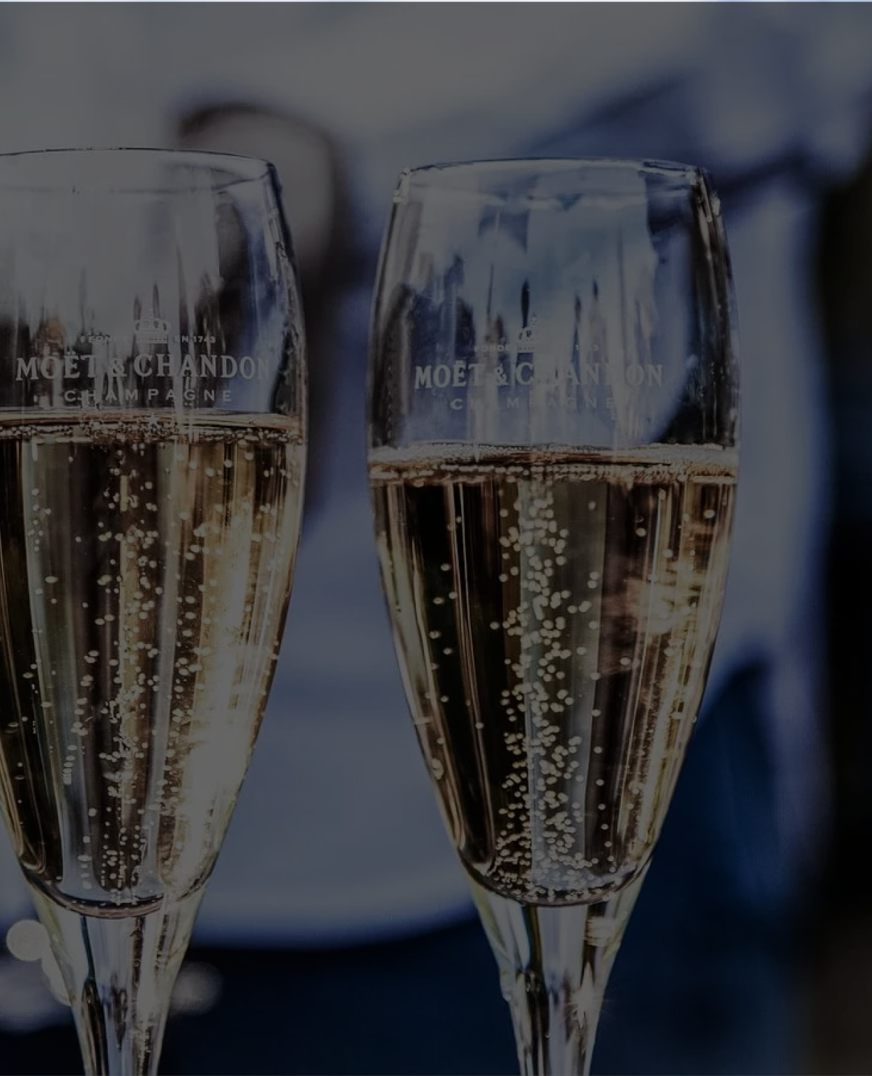 Nahaufnahme von zwei Champagnergläsern, gefüllt mit sprudelndem Moët & Chandon, deren Prickeln im Glas deutlich sichtbar ist.